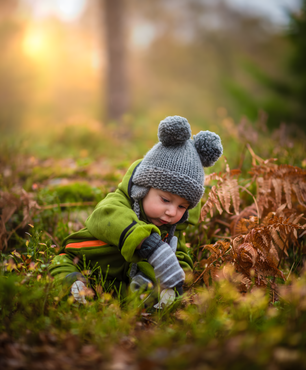 Jeune enfant explorant la forêt, illustrant les activités motricité et éveil des sens nature.